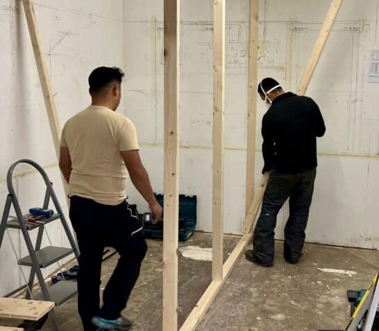 People on course building a stud wall