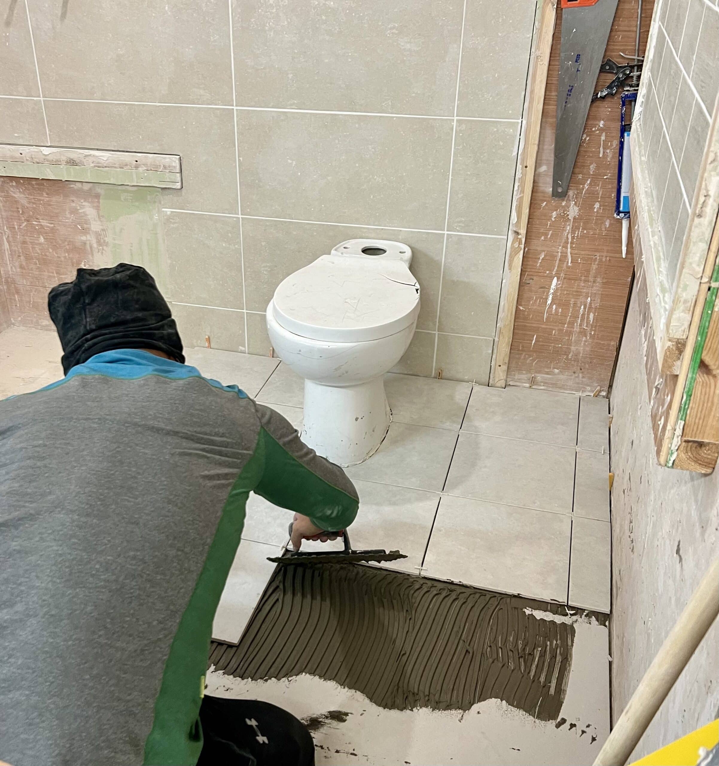 Person applying grout to floor