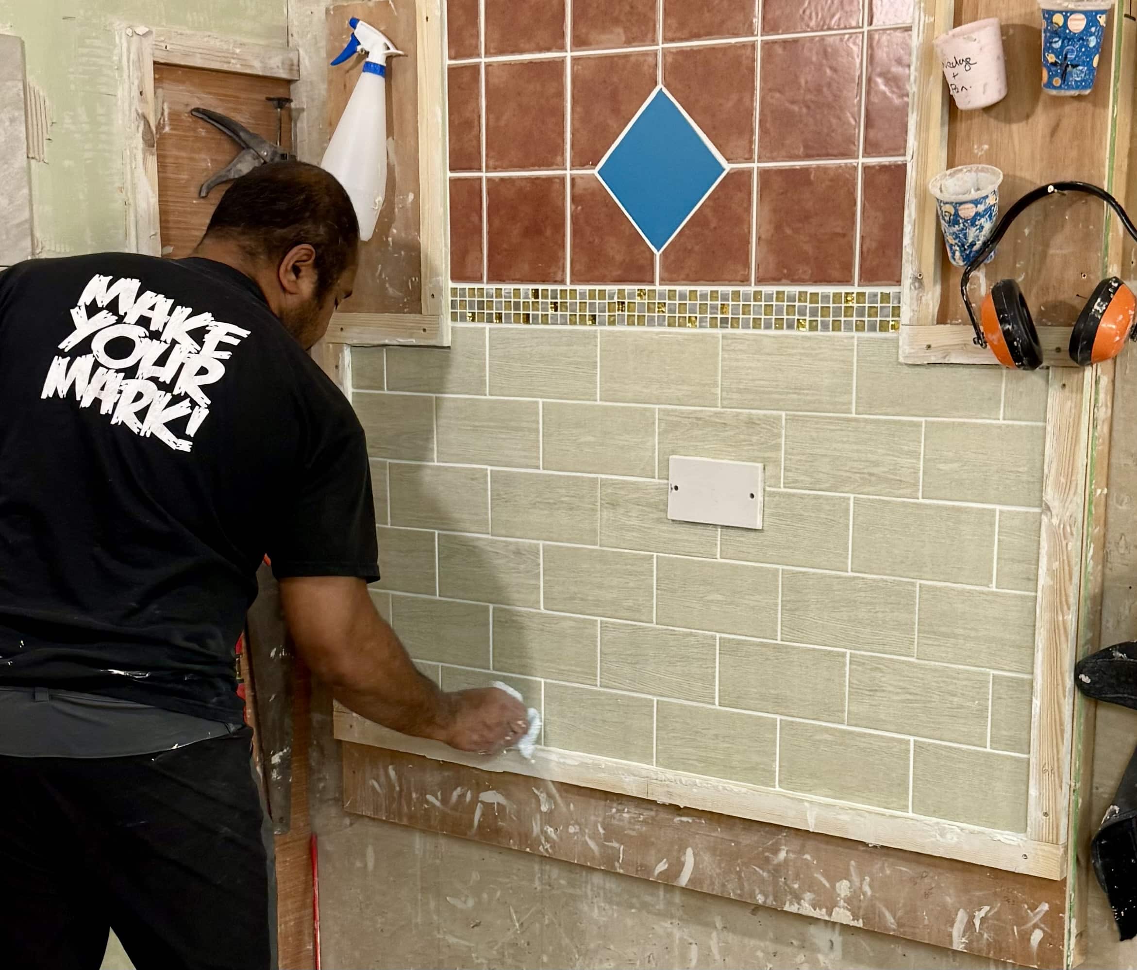 Person cleaning up tiled wall project