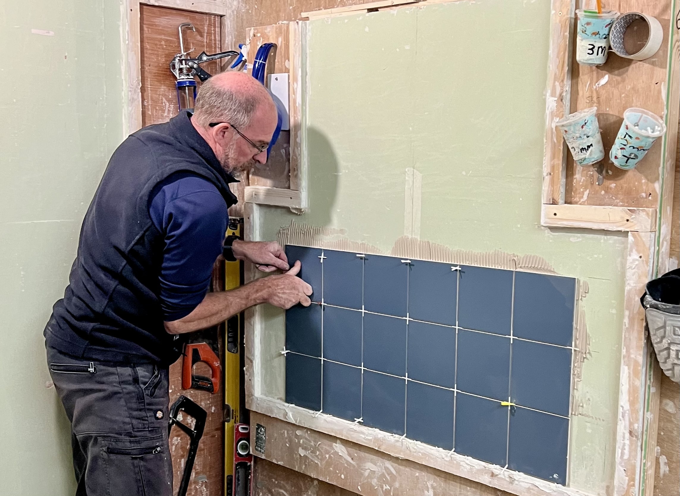 Person fixing tiles on day 1 of his training course