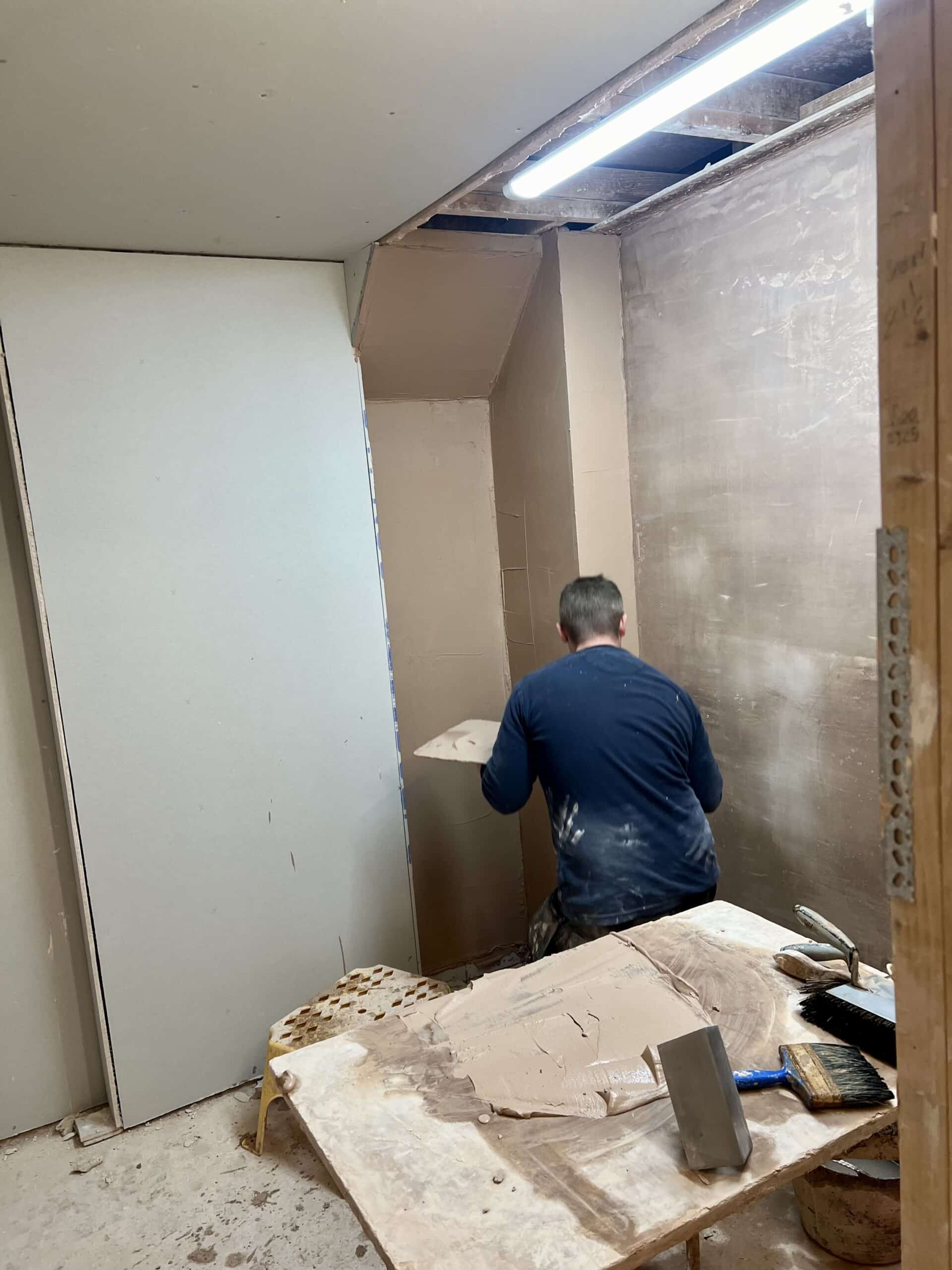 Person on a plastering course skimming his bay