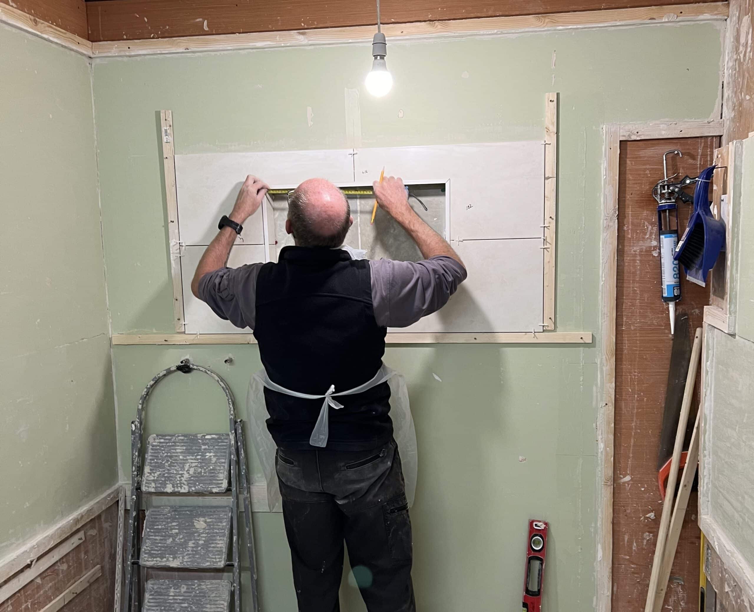 Person practicing tiling around a window
