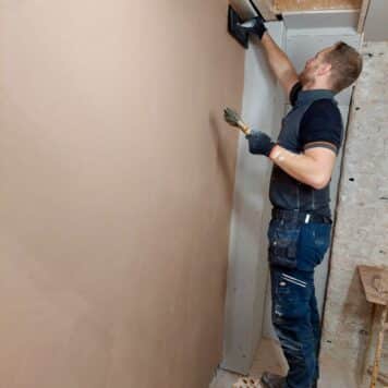 Person skimming a wall on a plastering course