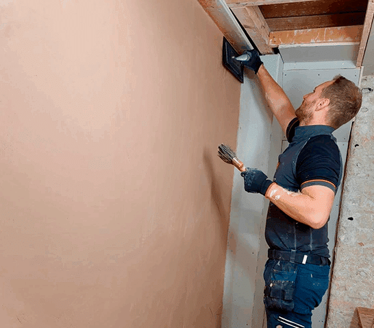 Person skimming a wall on a plastering course