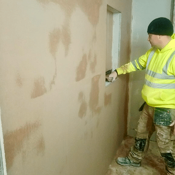 Person skimming a wall with a window opening