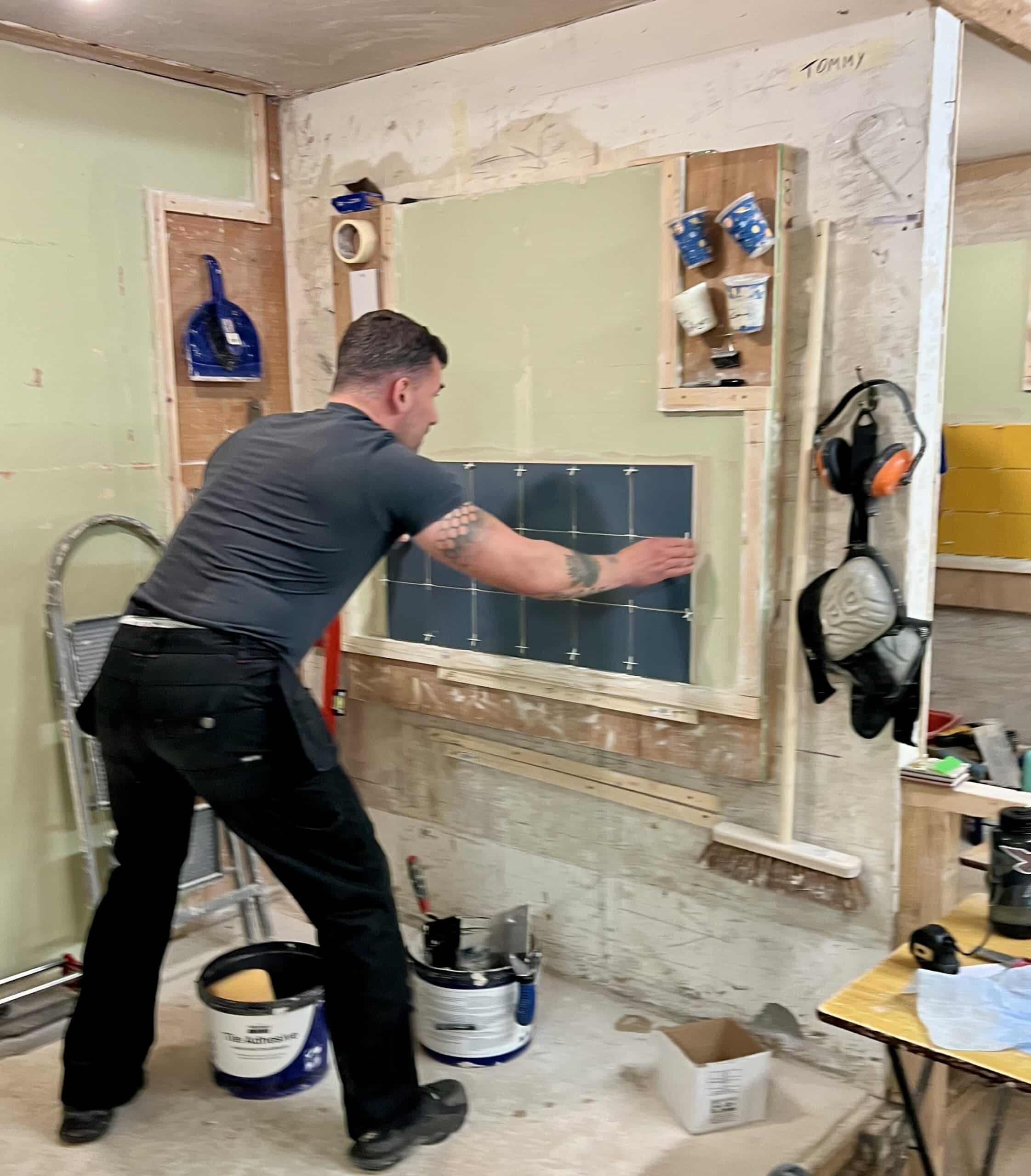 Person tiling a wall with 150x150 tiles