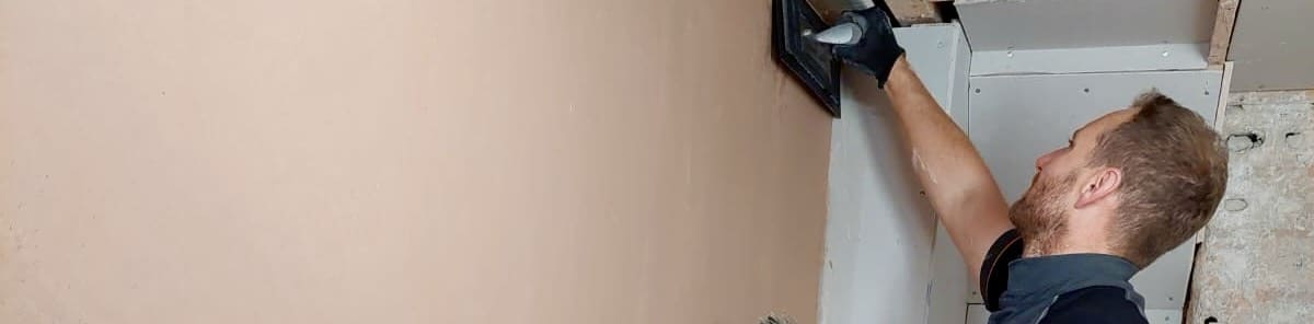 person using a flexi trowel to plaster their wall