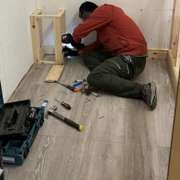 person fitting skirting boards in training bay