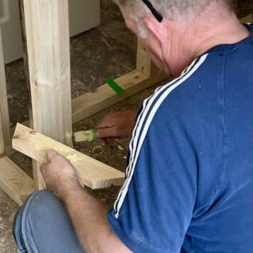person repairing damaged door casing