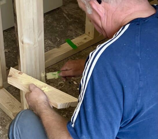 person repairing damaged door casing