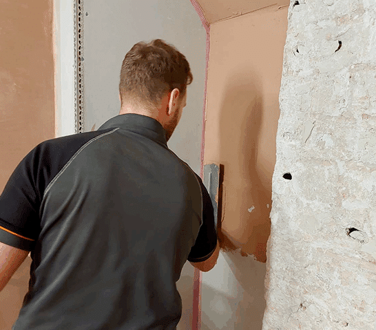 person skimming a section of wall