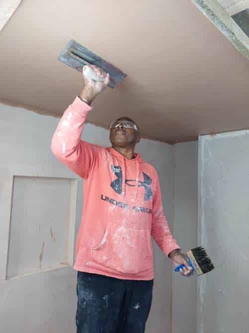 person skimming ceiling on plastering course