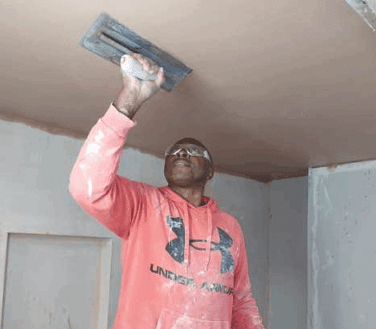 person skimming ceiling on plastering course