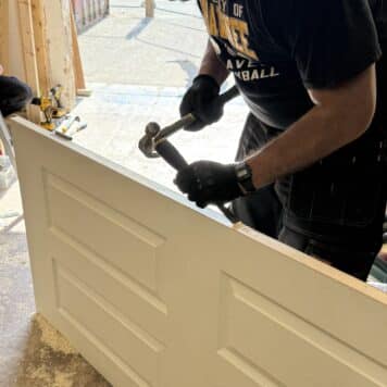 person using a chisel on door