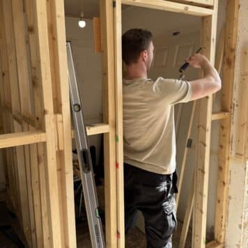 person using a chisel on door frame