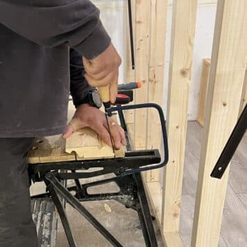 person using coping saw to cut skirting boards