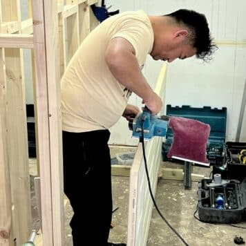 person using planer on door