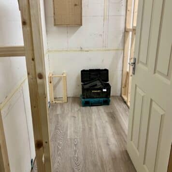 carpentry training bay with laminate flooring, pipe boxing and cabinet installed