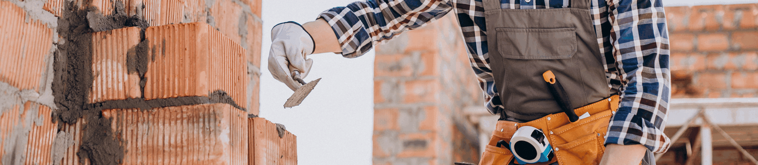 man building a brick wall wearing ppe