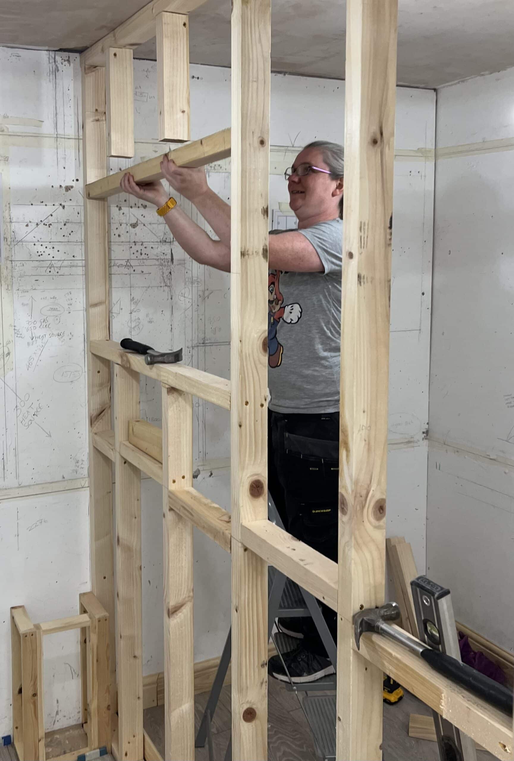 lady making a window opening in a stud wall