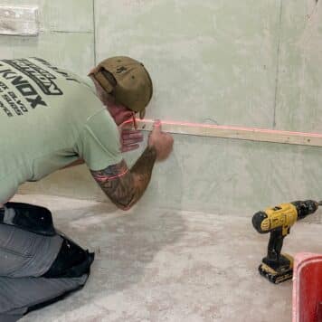 Person from Kent on a tiling course using a laser level