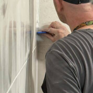 Person using grout finisher on tiling course