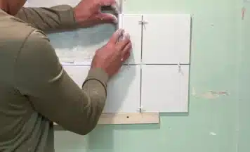 Student fixing tiling trim 3-way on a tiling course in Stoke-on-Trent, Staffordshire