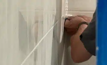 Student using silicone finisher on tiling course